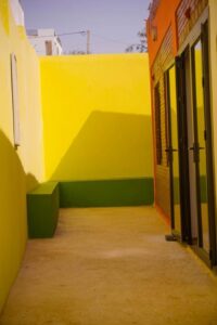 A hallway with a green bench and yellow walls.