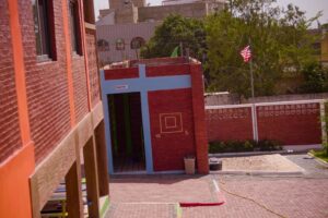 A red and blue building with a flag in the background.