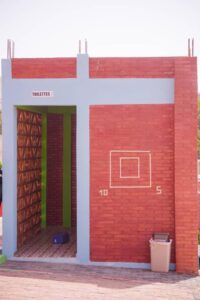 A red brick building with a blue door and green trim.