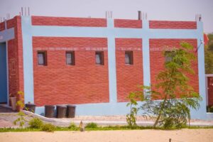 A red brick building with blue walls and windows.