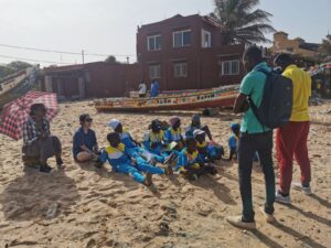A group of people sitting on top of the beach.