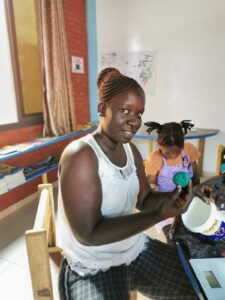 A woman holding something in her hand while sitting on a chair.