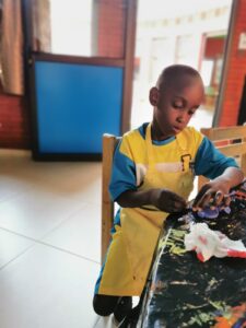 A young boy is playing with toys on the table.