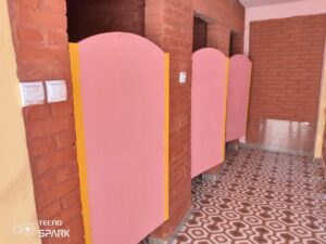 A row of pink stalls in a bathroom.
