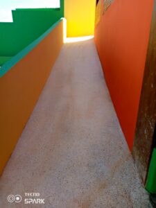 A hallway with an orange door and green walls.
