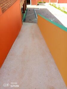 A walkway with orange walls and green trim.