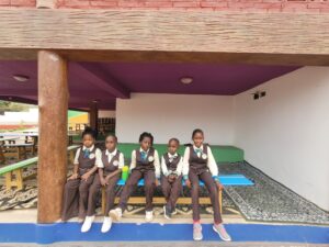 A group of young girls sitting on top of a bench.