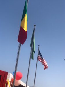 Three flags are flying in the wind.