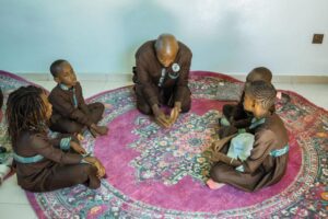 A group of people sitting on top of a rug.