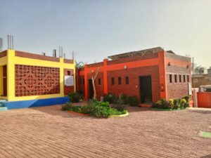 A brick building with a large blue and yellow wall.