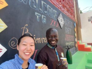 A man and woman holding cups in front of a wall.