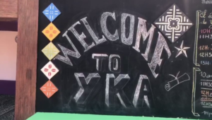 A chalkboard sign that says welcome to yka