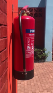 A red fire hydrant on the side of a building.