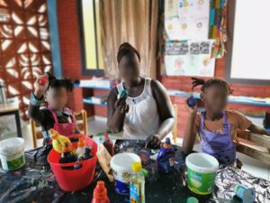 A woman sitting at the table with two children.
