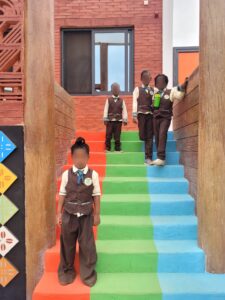 A group of children standing on top of colorful stairs.