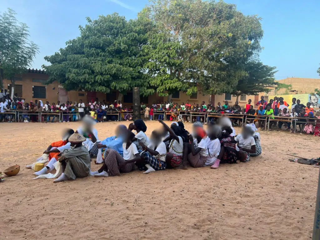 A group of people sitting on the ground.